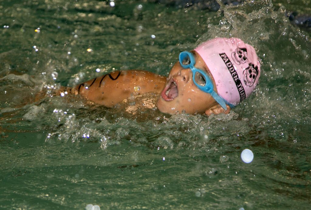 A swimmer takes a breath sideways.