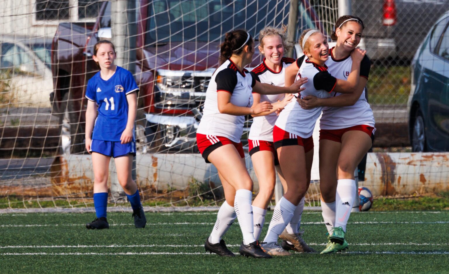 Bellingham players celebrate in a huddle of hugs and smiles.