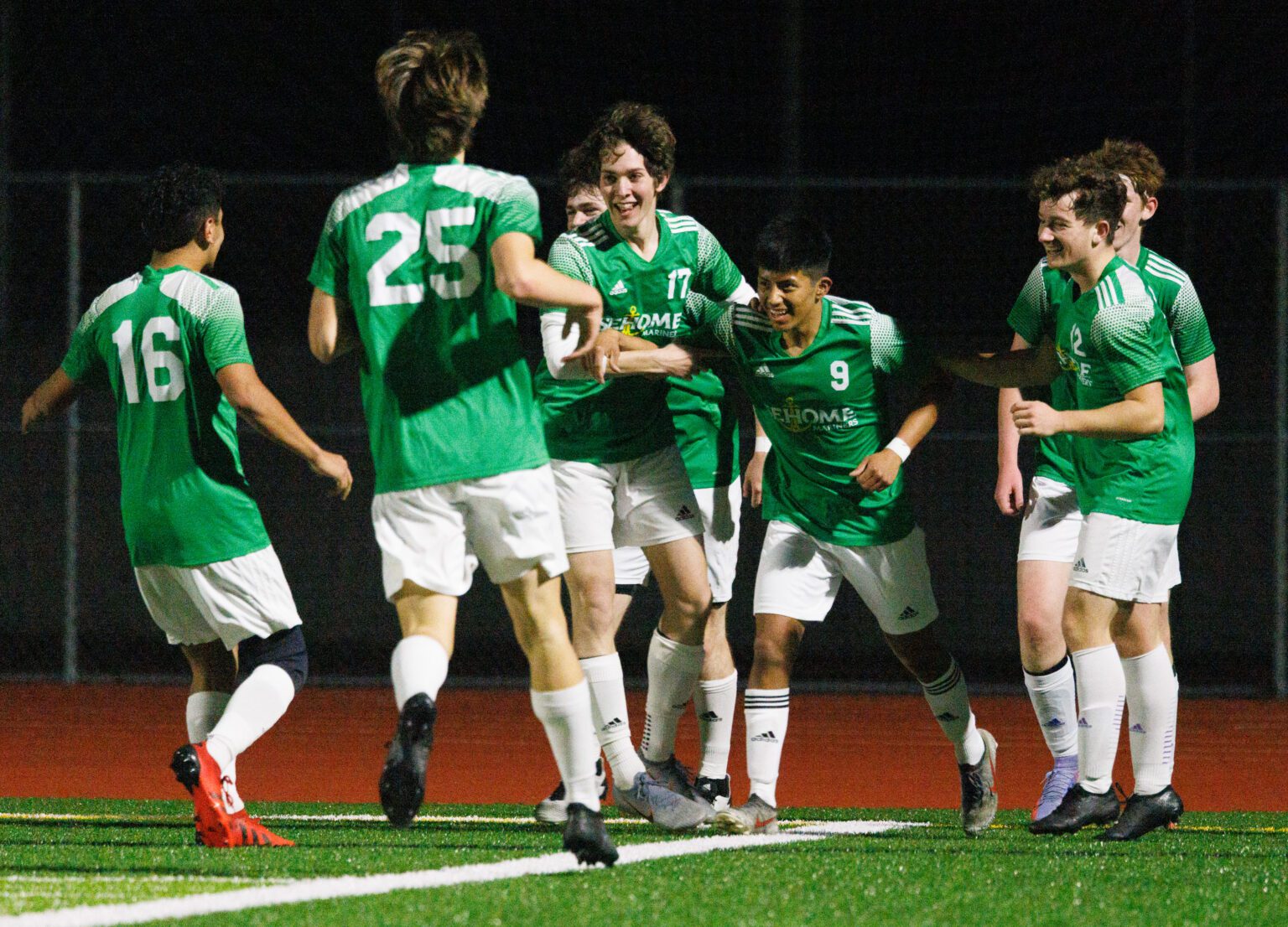 Sehome players surround teammate Gilberto Andrews (9) after he scores a goal.