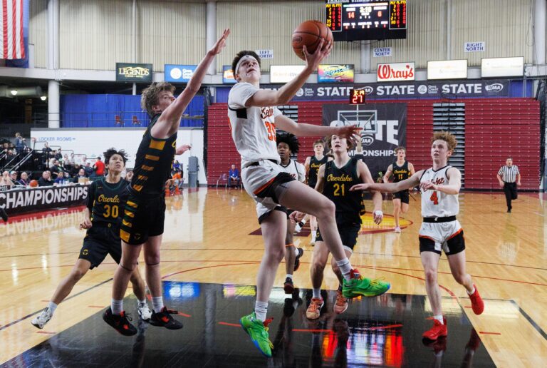 Blaine's Carson Lehnert throws a shot back over his shoulder as defenders try to reach over him for the ball.