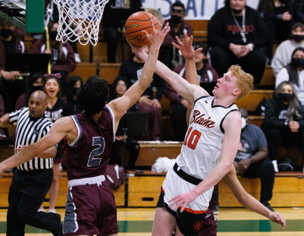 Blaine's Cole Thomas reaches out for the shot as Wahluke's Arnoldo Ramos blocks the ball.