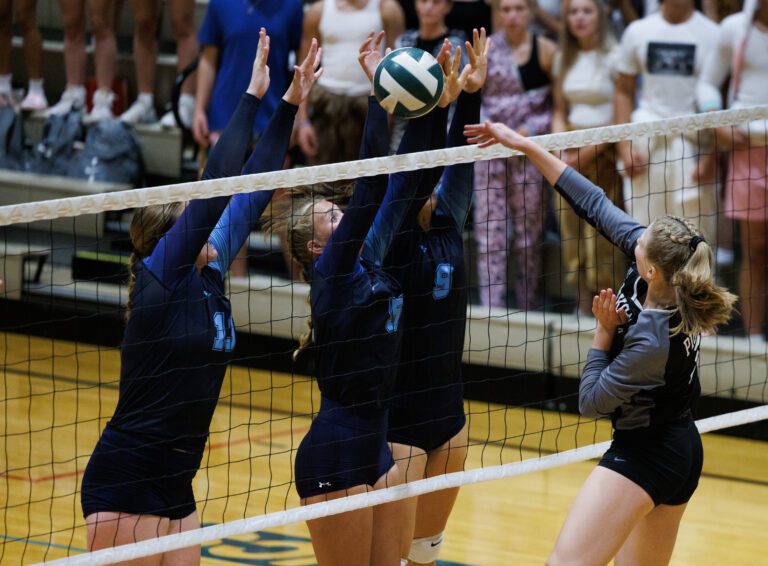 Lynden Christian’s Tabitha DeJong, Avery Lenssen and Malia Johnson block a shot by Nooksack Valley's Tana Hoekema over the net.