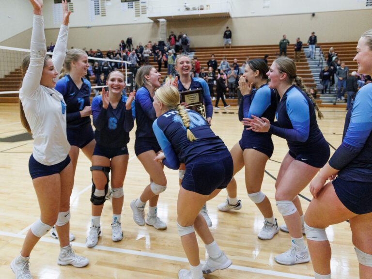 After getting their photo taken with the trophy, Lynden Christian celebrates in a huddle.