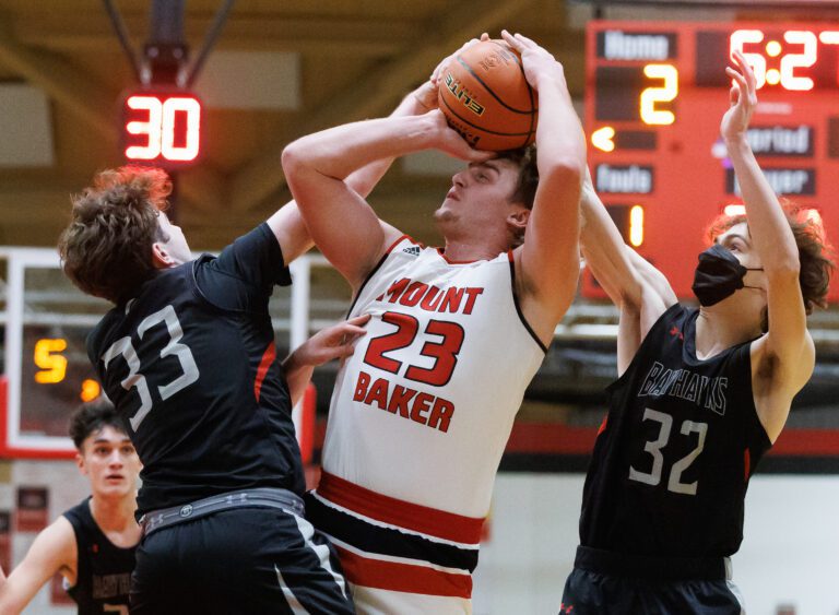 Mount Baker’s Ethan Larson is defended by Bellingham's Harmon Wienkers, left, and Grayson Stone from both sides.