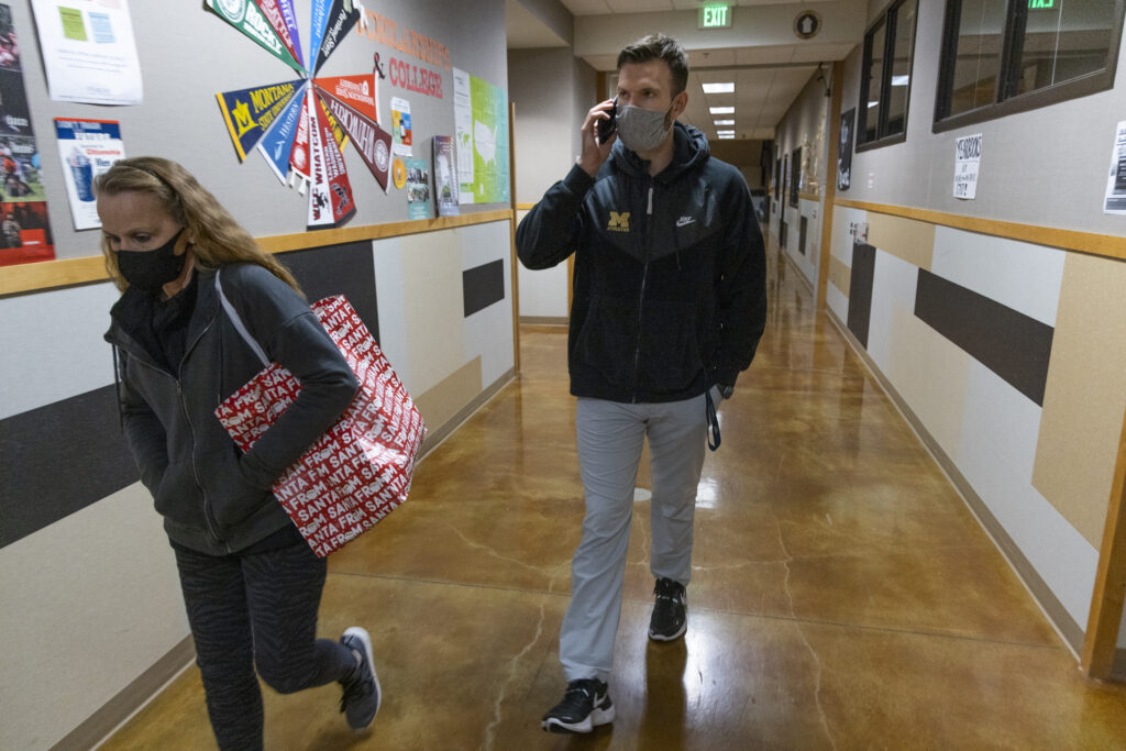 Constantly on the phone, Meridian Athletic Director Bryant Michaelson escorts Tami McMains through the main building.