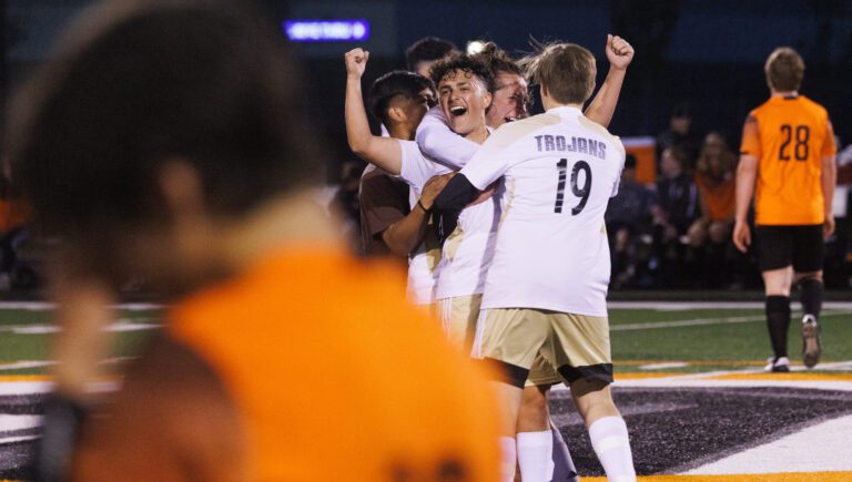 A Blaine players walk off the field as they put up their hands in celebration.