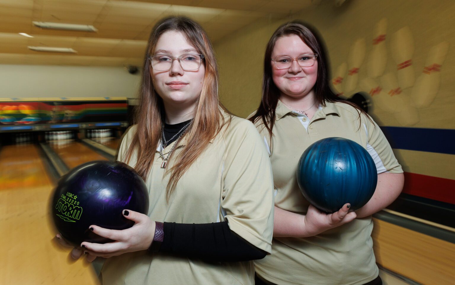 Meridian bowlers Emma Hill and Lexi Garvin holds up bowling balls.