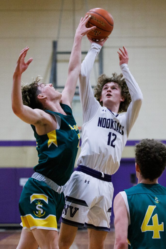 Sehome's Mathew Storms blocks a shot by Nooksack Valley's Bennett DeLange mid-air.