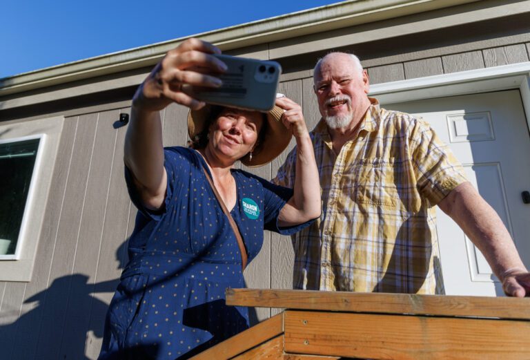 State Senate candidate Sharon Shewmake takes a selfie with supporter Steve Hodel while doorbelling.