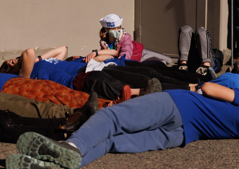 Sahale Gamblewood looks up as she and other protesters stage a die-in in front of the Target store.