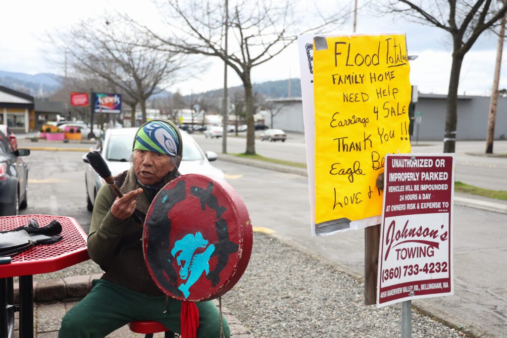 Eagle Bear performs a chant of hope from his parking lot post next to signs asking for help.