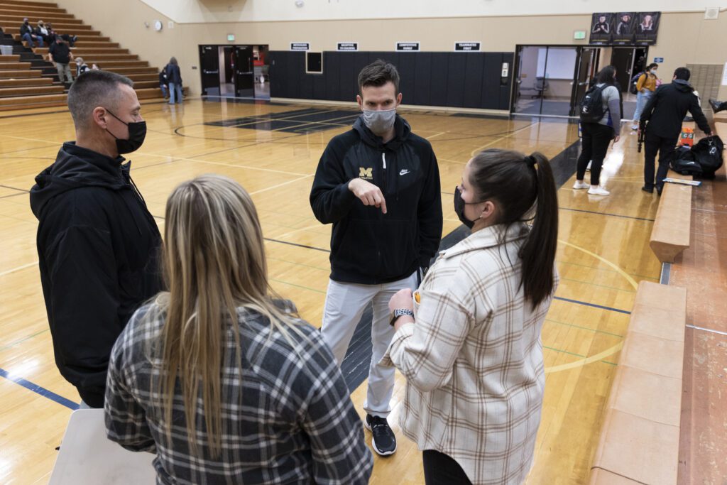 After a game is over, Meridian Athletic Director Bryant Michaelson, center, chats with coach Bree Park, left.