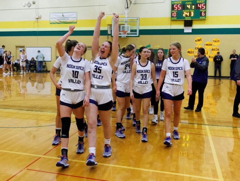 Nooksack Valley’s Lainey Kimball and Ella Perry celebrate as they cheer with their arms raised.