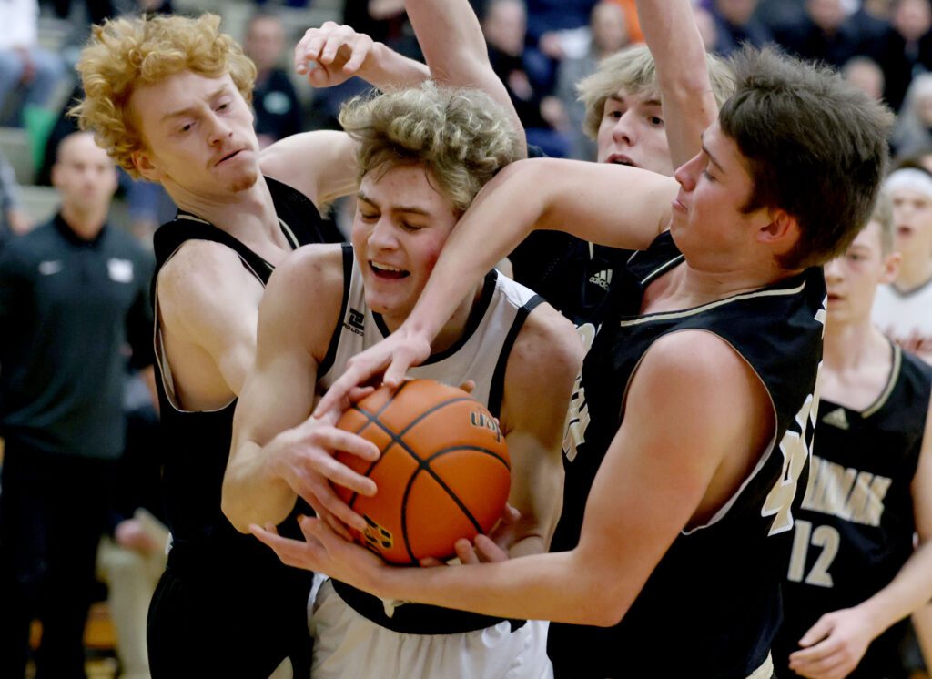 Meridian’s Tyrel Brooks, right, tries to grab the rebound away from Blaine’s Noah Tavis as he is surrounded by multiple defenders.