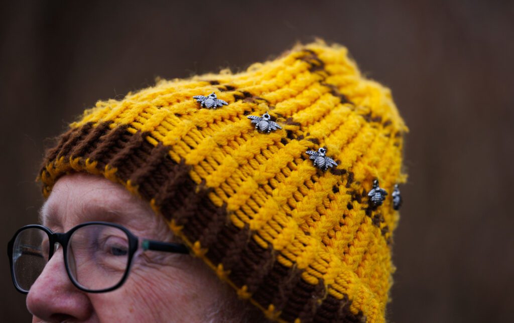 Bee charms line up the bee-colored beanie on local beekeeper Micheal Jaross.