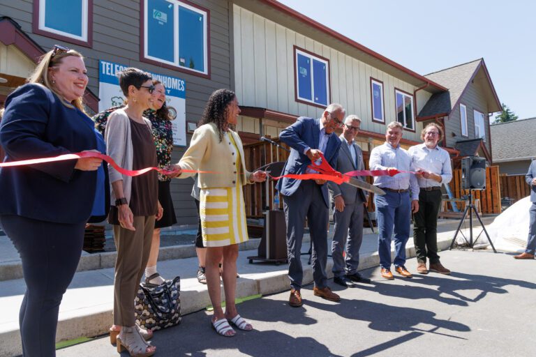 Gov. Jay Inslee cuts a red ribbon at a ceremony.