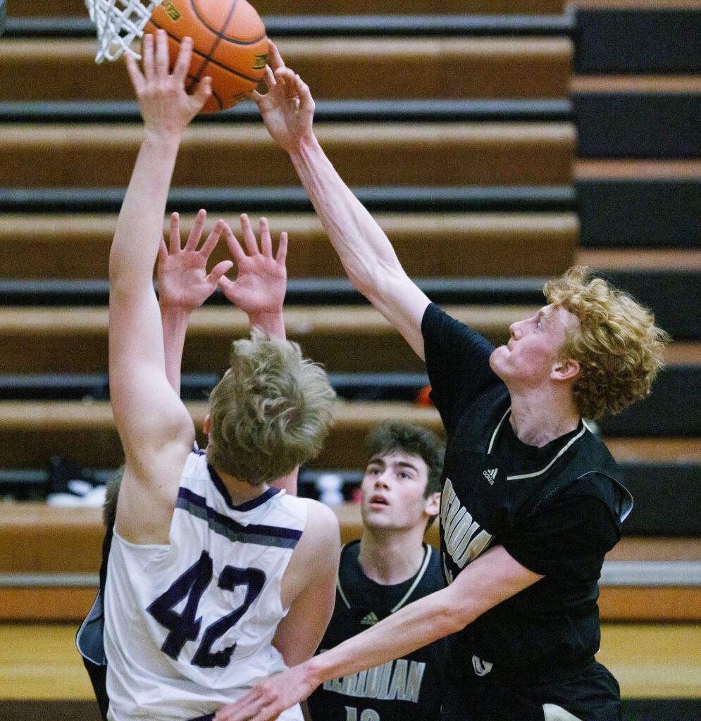 Meridian's Hunter Jones blocks a shot by Nooksack Valley's Brady Ackerman.