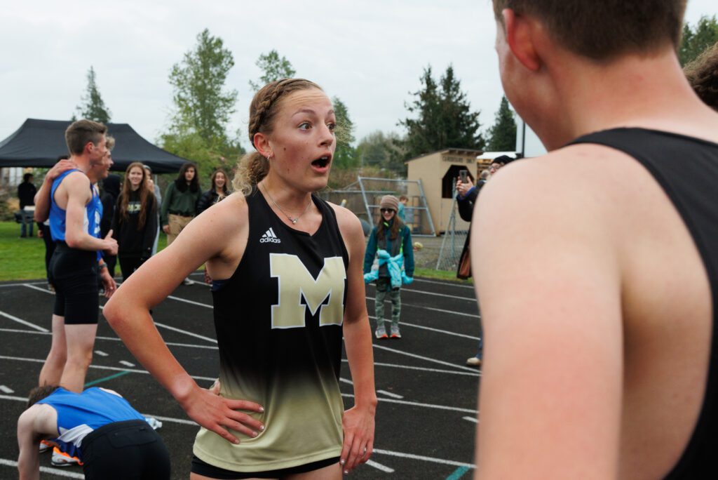 Meridian’s Kayla Aalpoel reacts as her teammates inform her of her school record time.