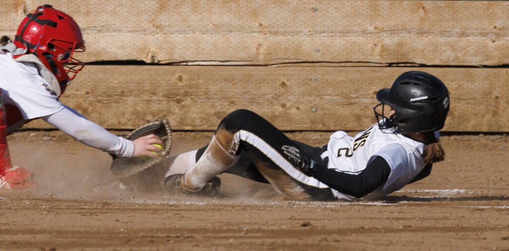 Meridian’s Maddy Ritter beats the tag at home by sliding feet first to the plate.