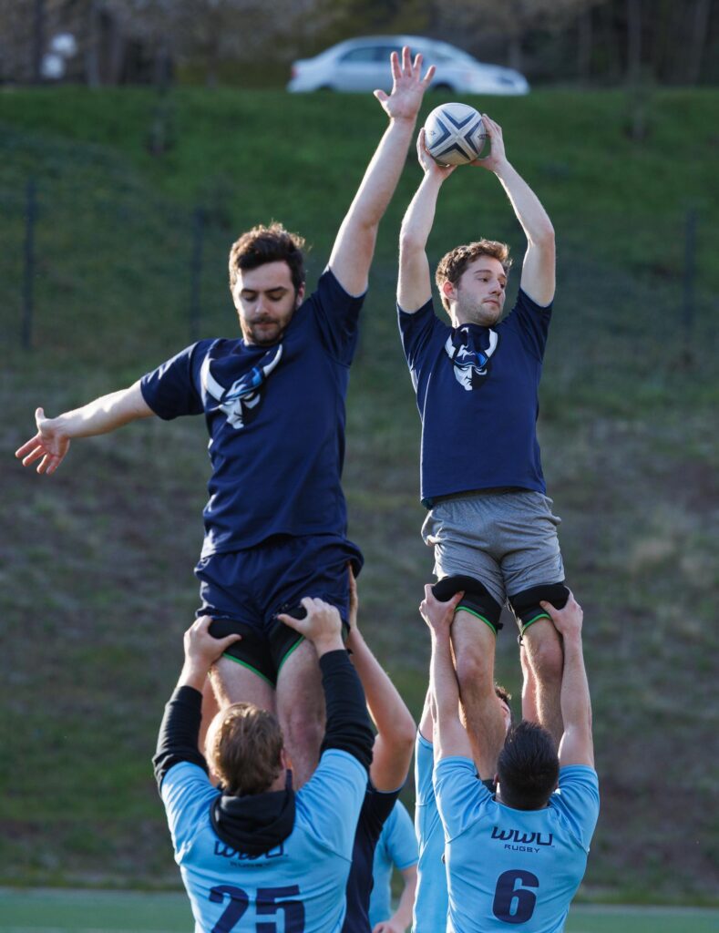 Brahm VanWoerden, right, catches the ball during a line out throw where he and another person is held up.