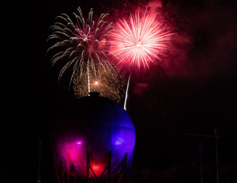 Fireworks of various colors and size explode behind the Acid Ball.