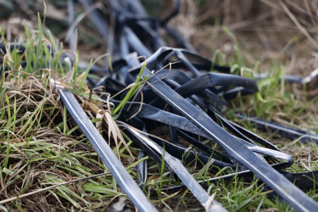 Irrigation tape and other supplies laid out on the grass.