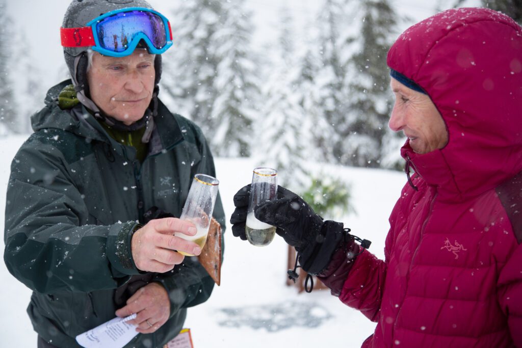 The pair toast with glasses of sparkling cider.