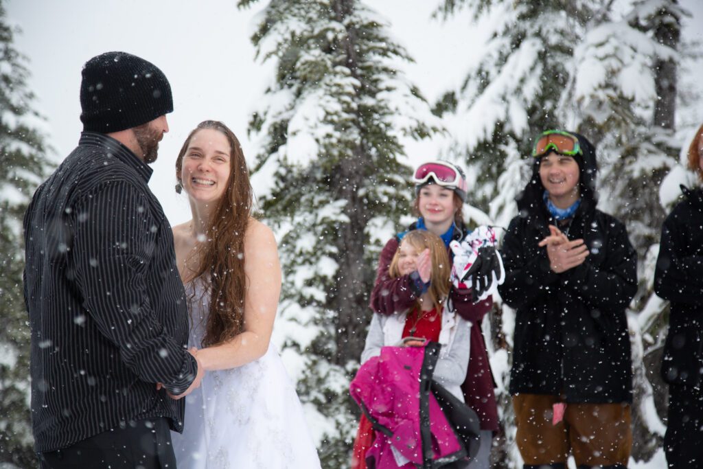 Tara and Gilbert smile and laugh as snow falls and close friends and family celebrate their reunion.