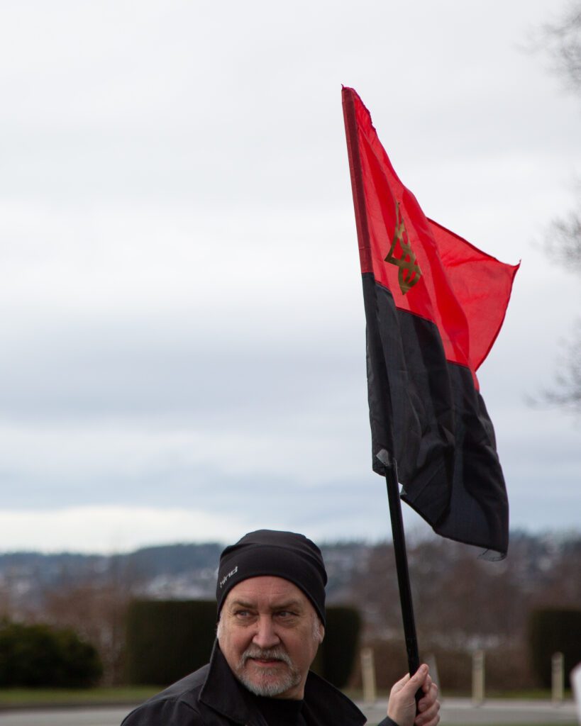 Rally organizer Charles Sullivan flies the flag of the Ukrainian Insurgent Army.