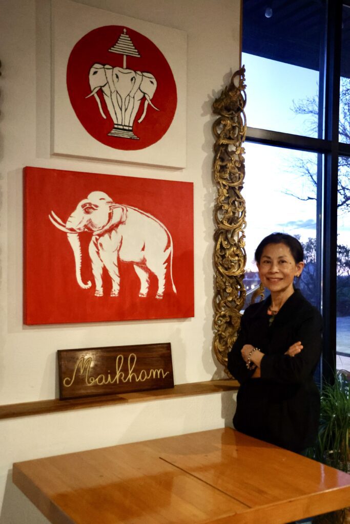 Klimo poses with her painting of a single white elephant. White elephants signify prosperity in Thai culture, she said.