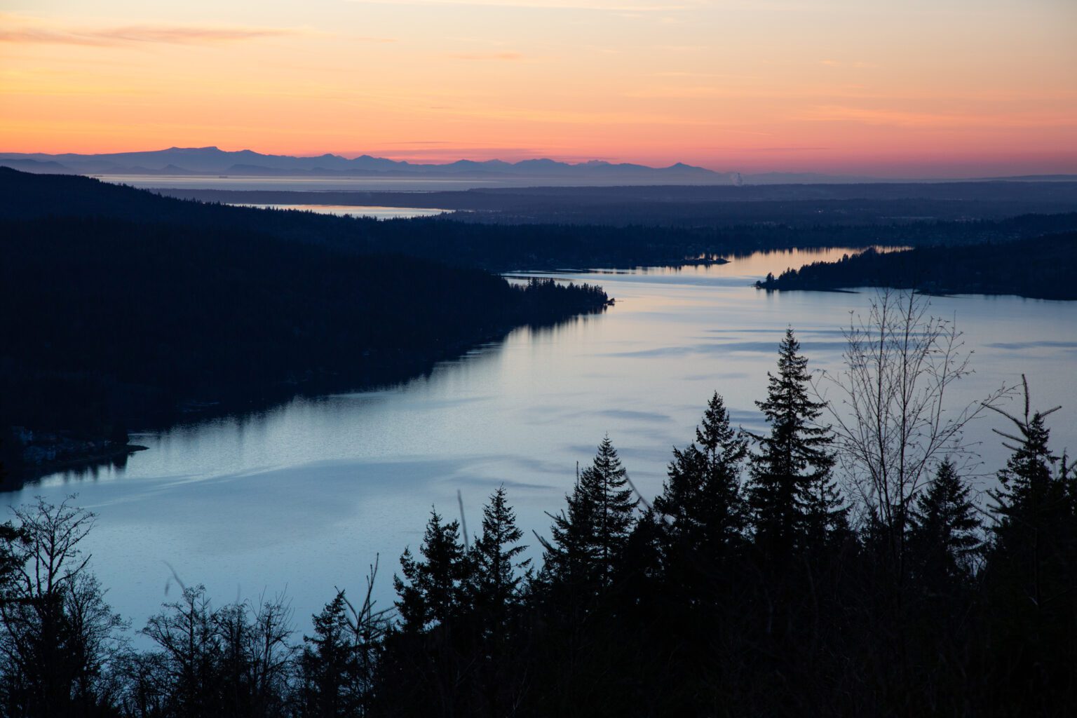 Lake Whatcom with the sun setting over the horizon.