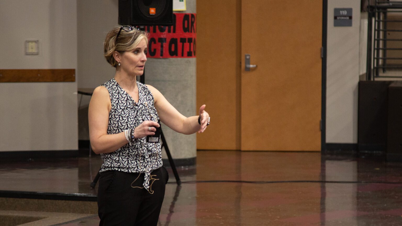 Karin "Kristi" Dominguez speaks to the community as she gestures with both hands.