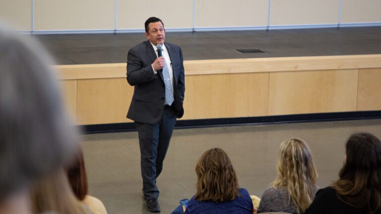 Superintendent candidate Tavis Peterson meets with the Lynden community as he talks with a microphone in hand.