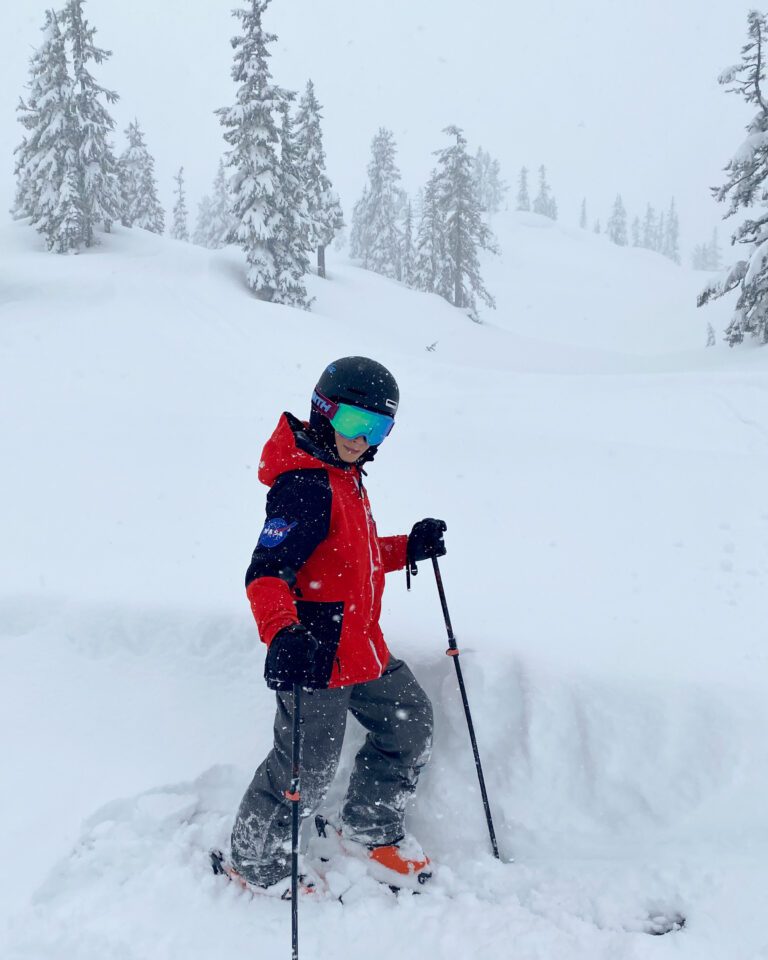 Five-foot-tall Mac Trowbridge stands on a run with his skis.