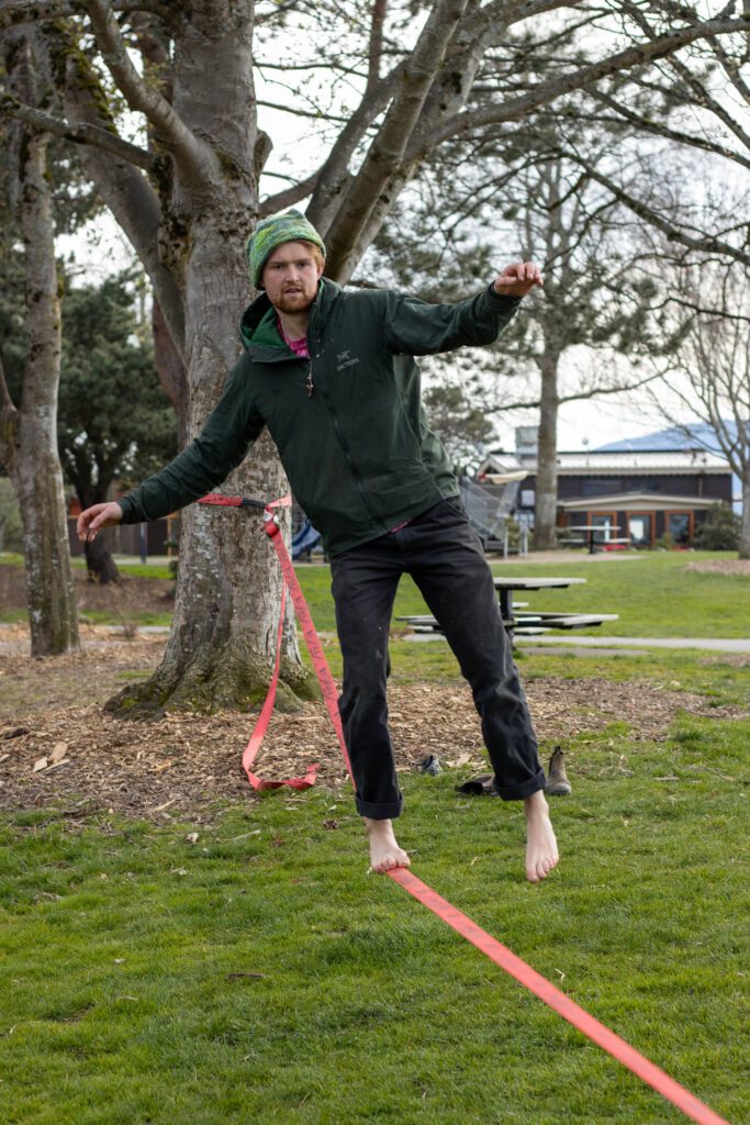 Kip Creech demonstrates how to slackline as he balances on one foot.