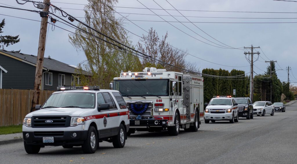 Dozens of vehicles partook in a procession in a straight line on the road.