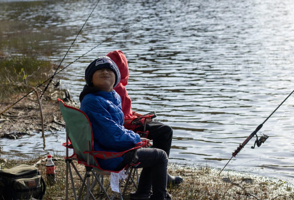 From left Jayden, 9, and Otilio, 8, smile at the camera as they wait for a fish to bite.