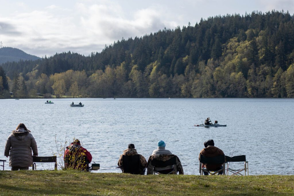 Fishers sit on the water or go out to the center of the lake on boats and kayaks to catch fish.