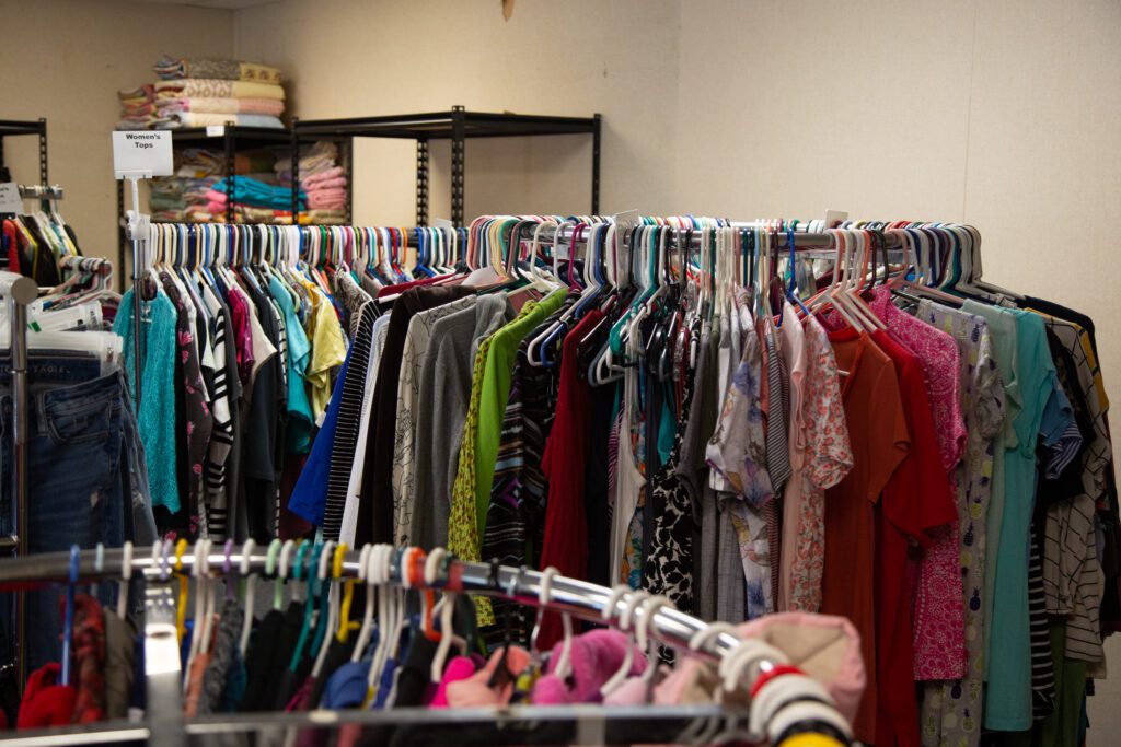 The Family Support Center has a closet of donated clothes for children and adults on several racks and shelves.