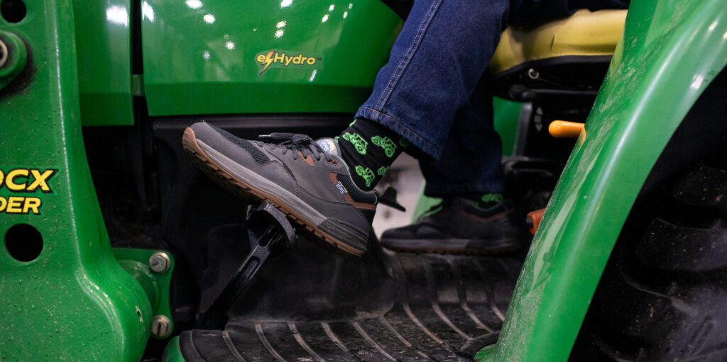 Mike Adkinson flashes his tractor socks while his foot is on the pedal.