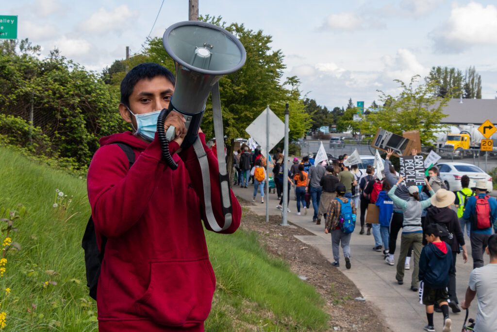 Alfredo Juarez yells support to the crowd of Marcha Campesina as they walk past.