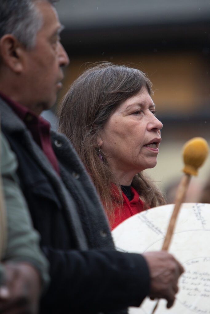 Siam'elwit sings the opening prayer next to a drummer.