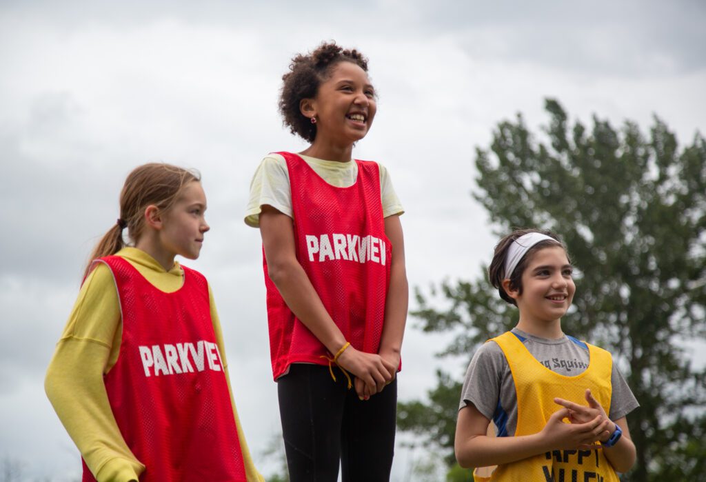 Triple jump winner Gabi Jude, center, smiles from atop the podium with Ruby Trulson, left, and Michela Pihos-Heim by her side.