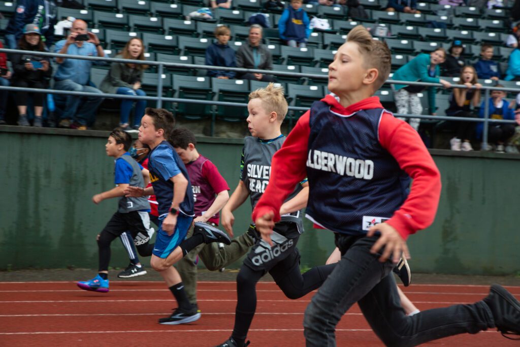 Silver Beach's James Fahey-Smith and Alderwood's Michael Datskiy race as attendees watch from the bleachers.