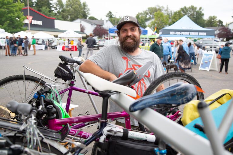 Alec Howard, with a newly-launched bike valet service, at the Birchwood International Market with his bikes.