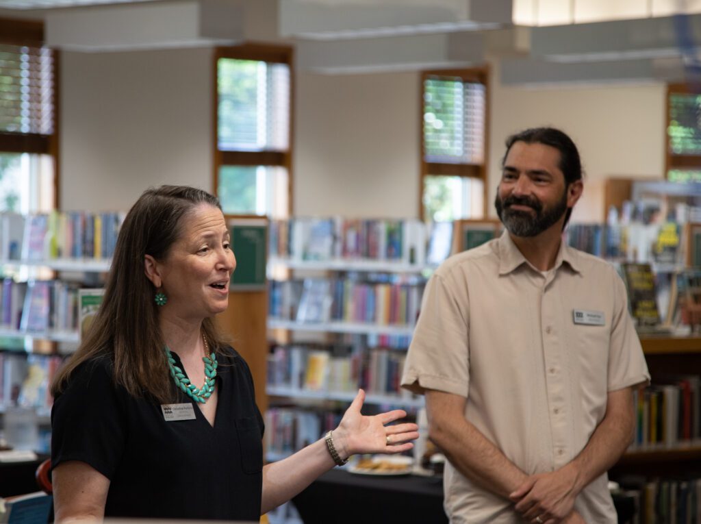 Whatcom County Library System executive director Christine Perkins as deputy director Michael Cox smiles while they talk to the crowd.