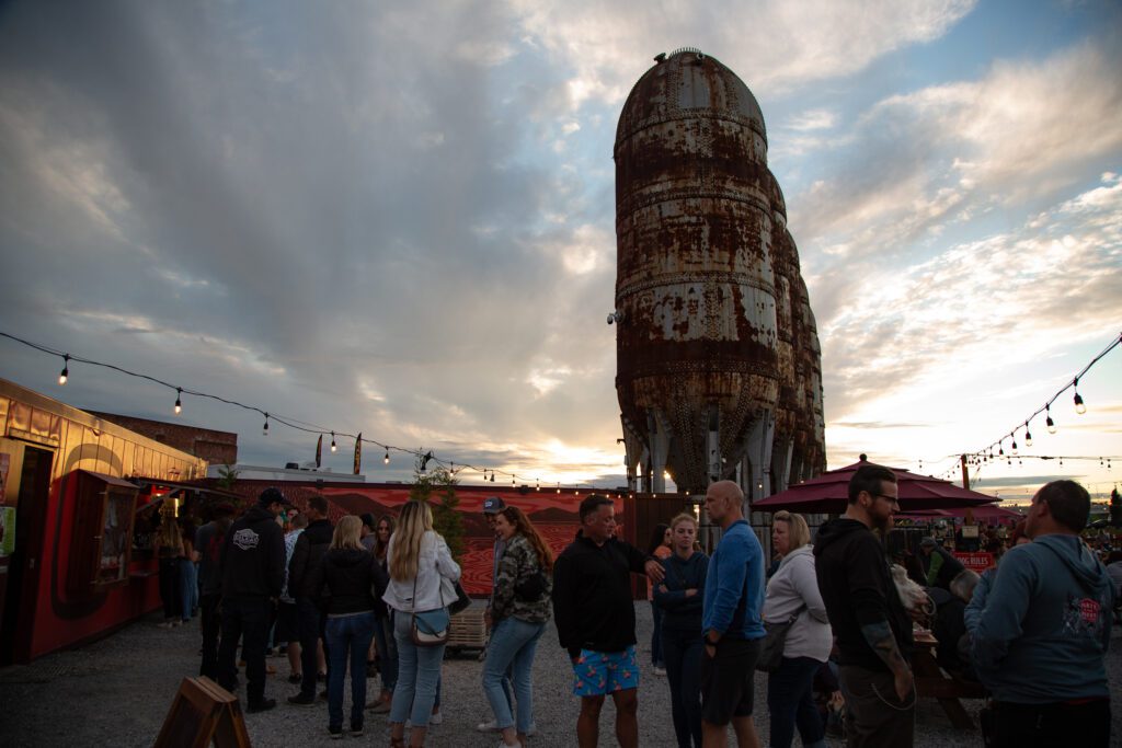 People wait in a long line for beer at the Kulshan Trackside Beer Garden as the cloudy skies loom over them.