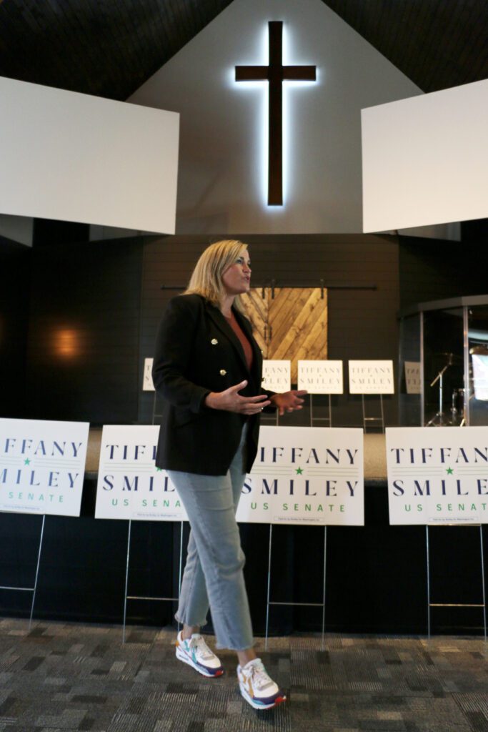 Republican U.S. Senate candidate Tiffany Smiley speaks in front of multiple signs with her name.