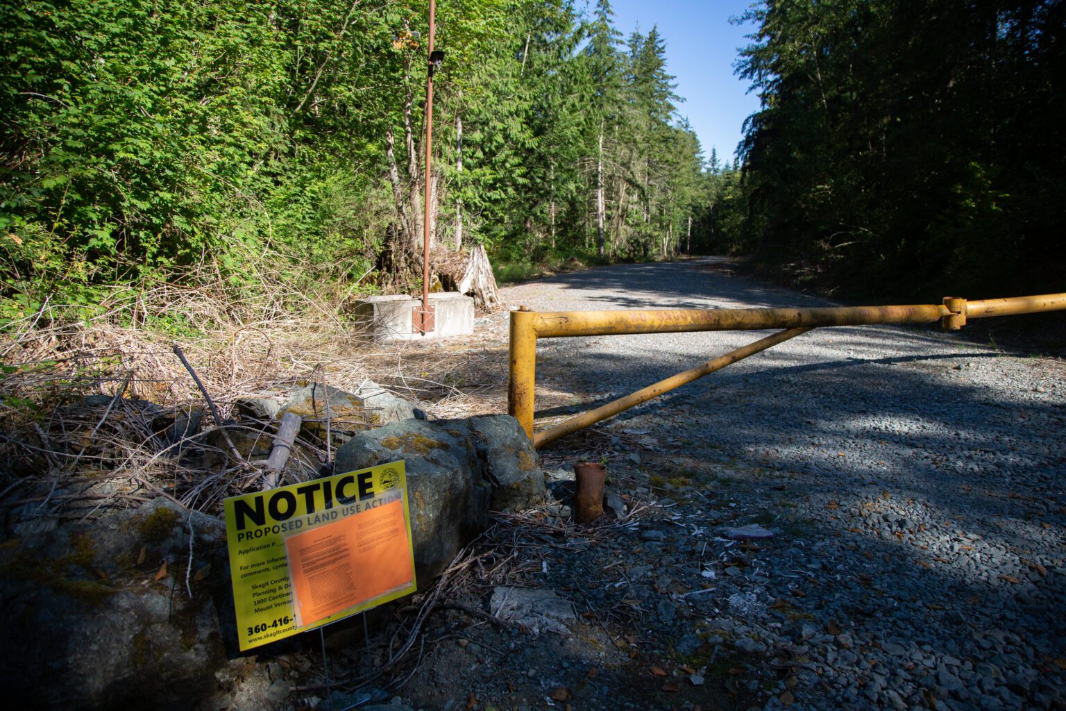 A yellow notice sits near the entrance of the gravel mine.