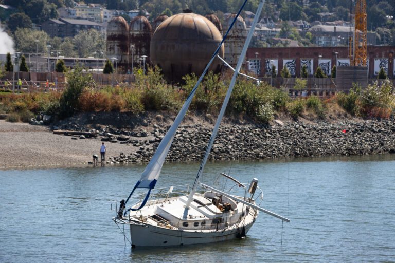 A grounded sailboat left to on the waters without any passengers.